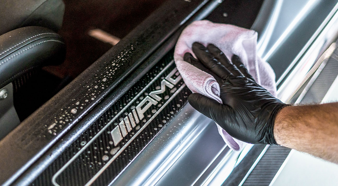Soft99 car-care-made Super Cloth microfibre cloth being used to wipe down cleaning agent on a car.